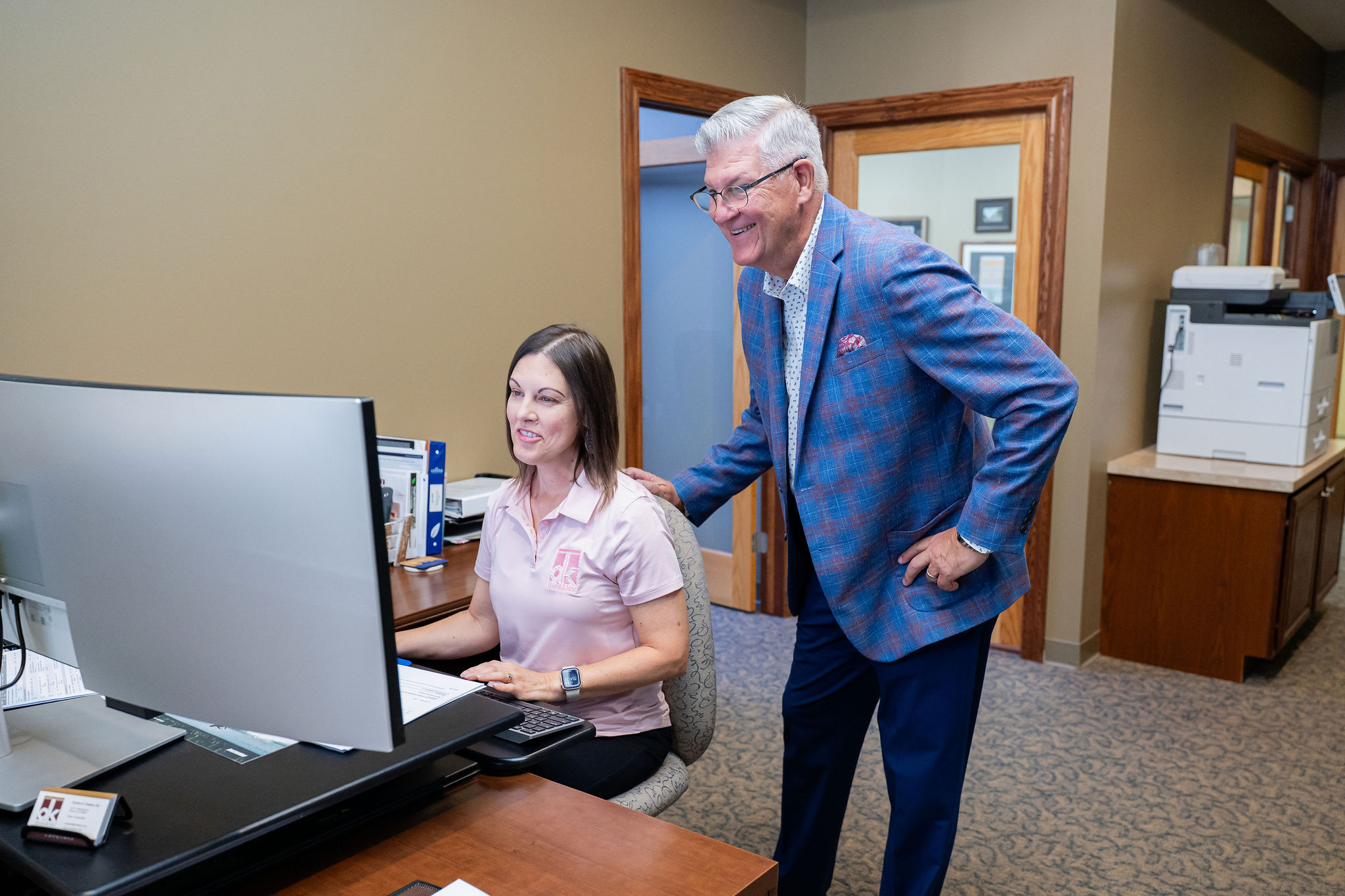 Two team members collaborating at a computer workstation in the office